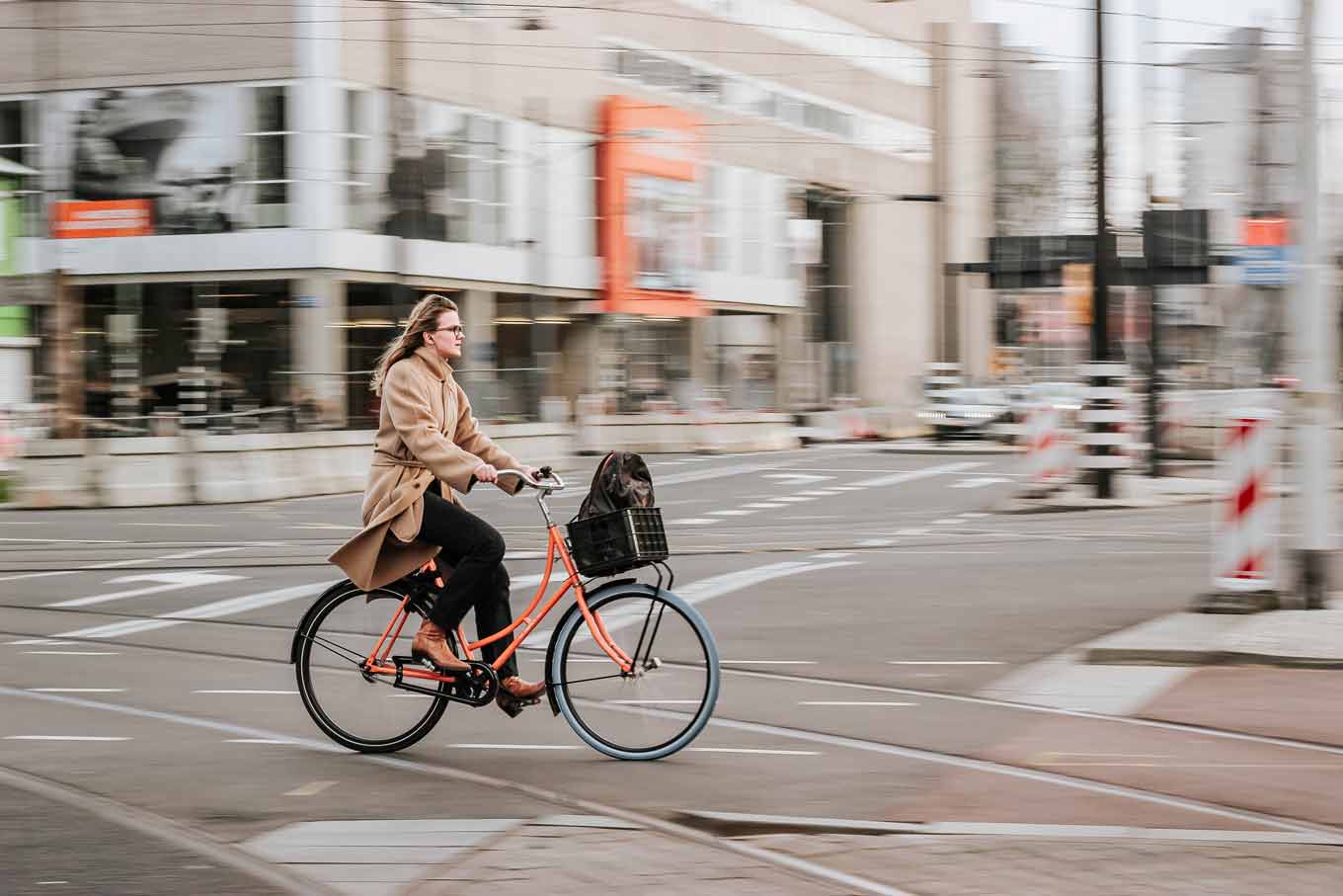 Een vrouw op een fiets die over een straat rijdt