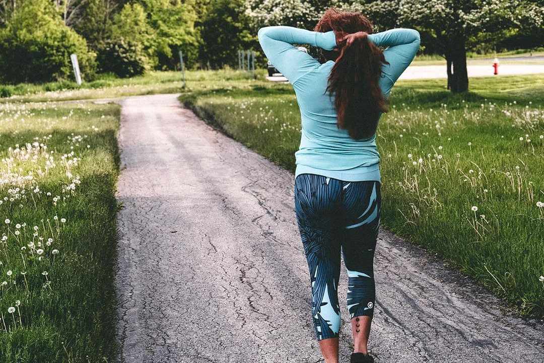 Een vrouw in Rsport activewear langs een verhard pad