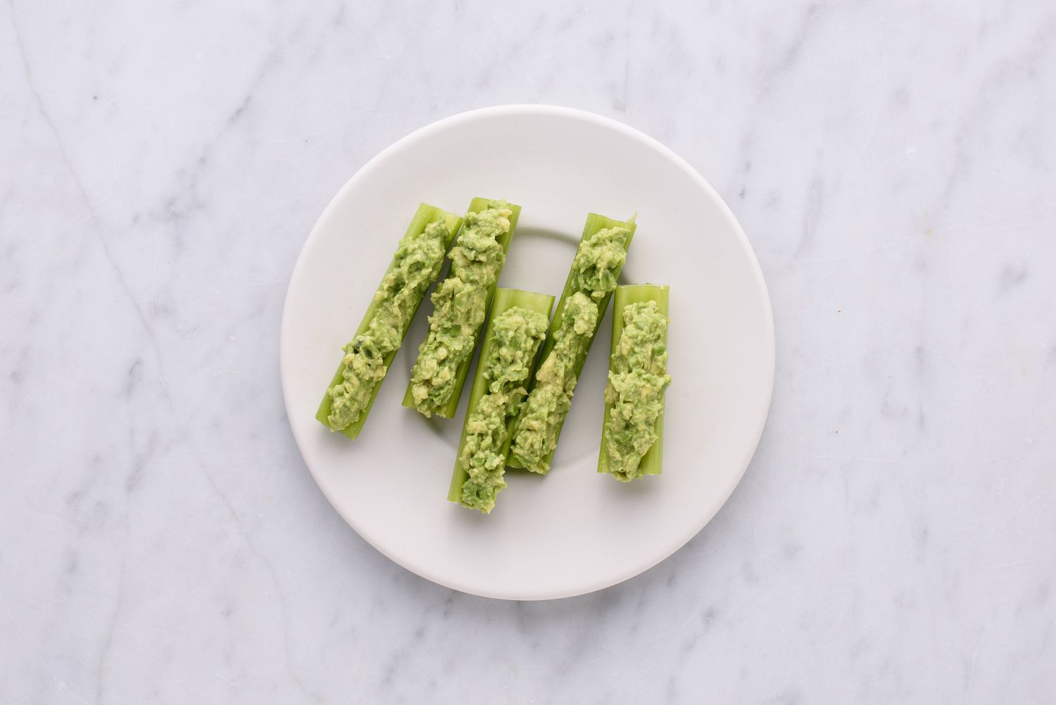 guacamole en selderij stokt op een bord