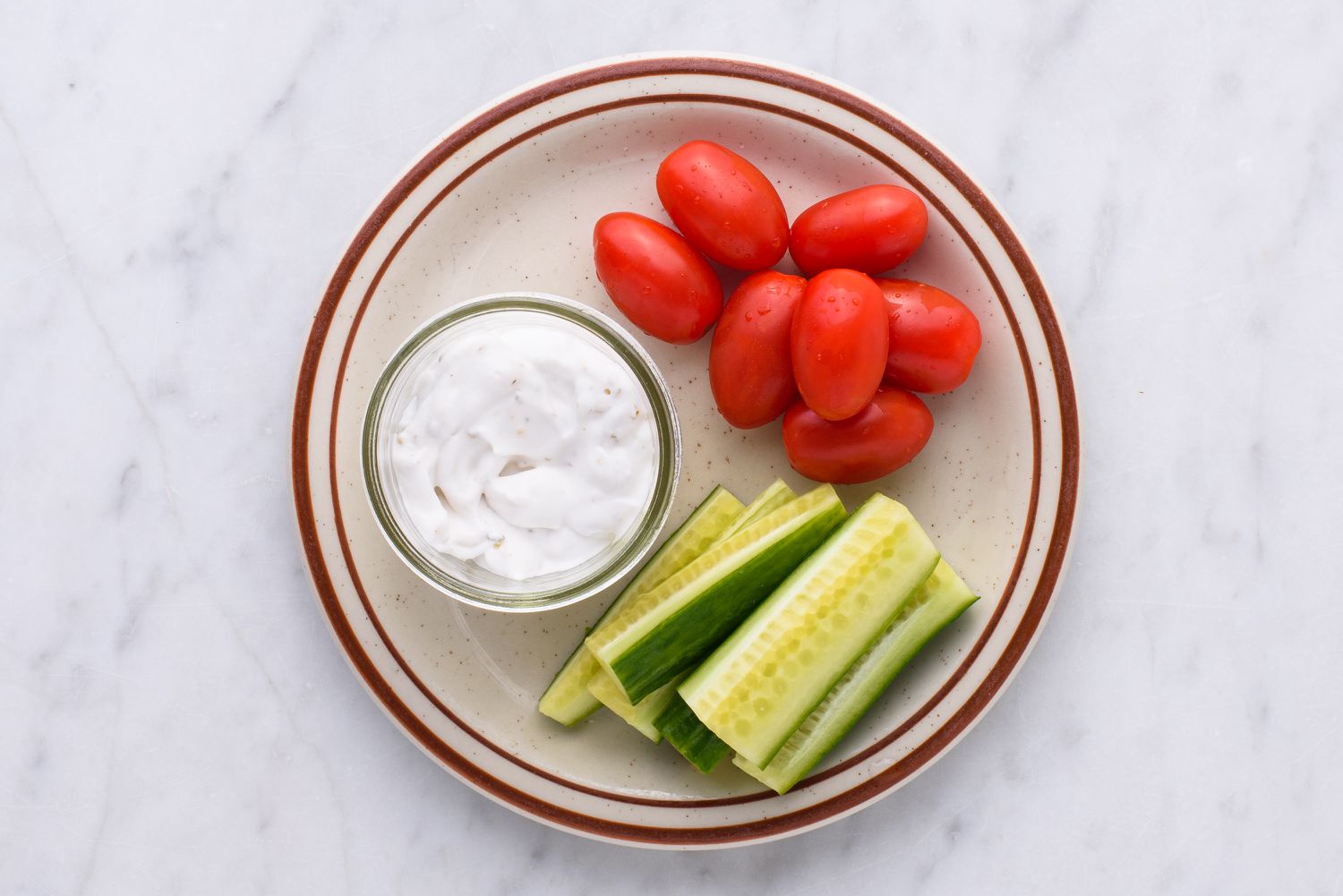 verse tomaten en komkommers met dip op een bord