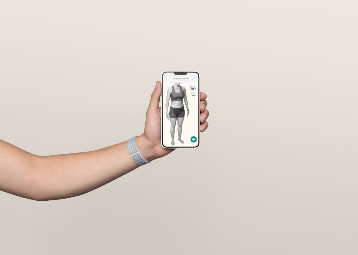 Een persoon met een smartphone die een 3D-lichaamssamenstellingsscan toont.