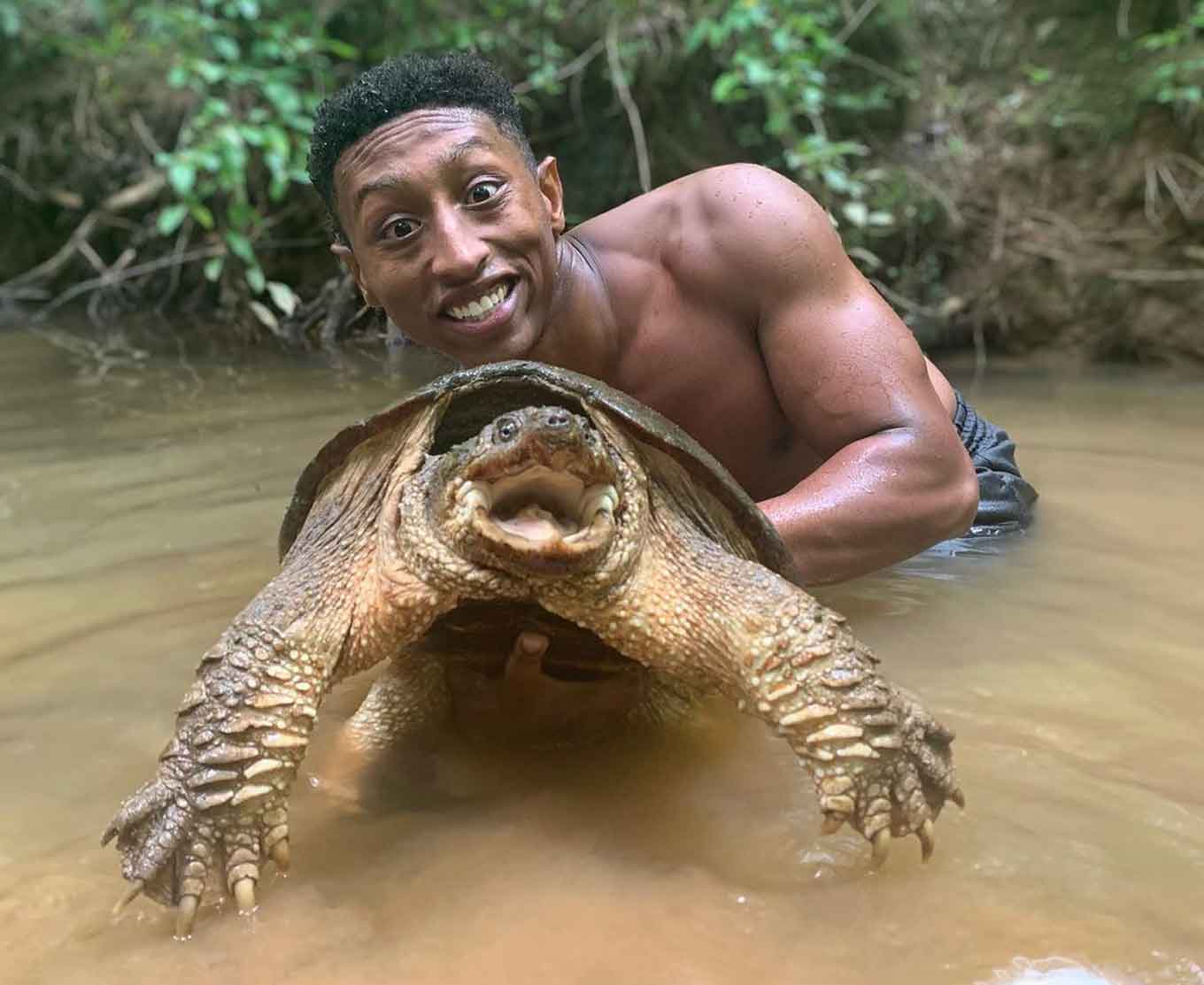 Christian Cave met een gewone knakkende schildpad in het water