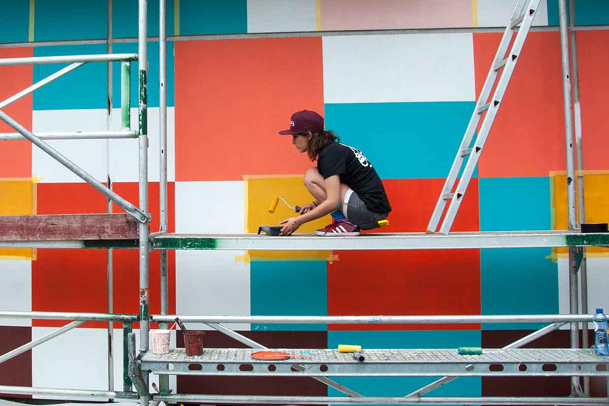 United Schildersschilders schilderen een kleurrijke Nederlandse gevangenis om vluchtelingen te huisvesten