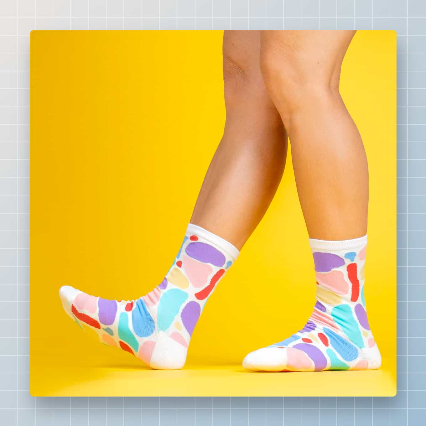 Een voetmodel dat Awesome Socks Club-sokken draagt voor een gedurfde gele achtergrond