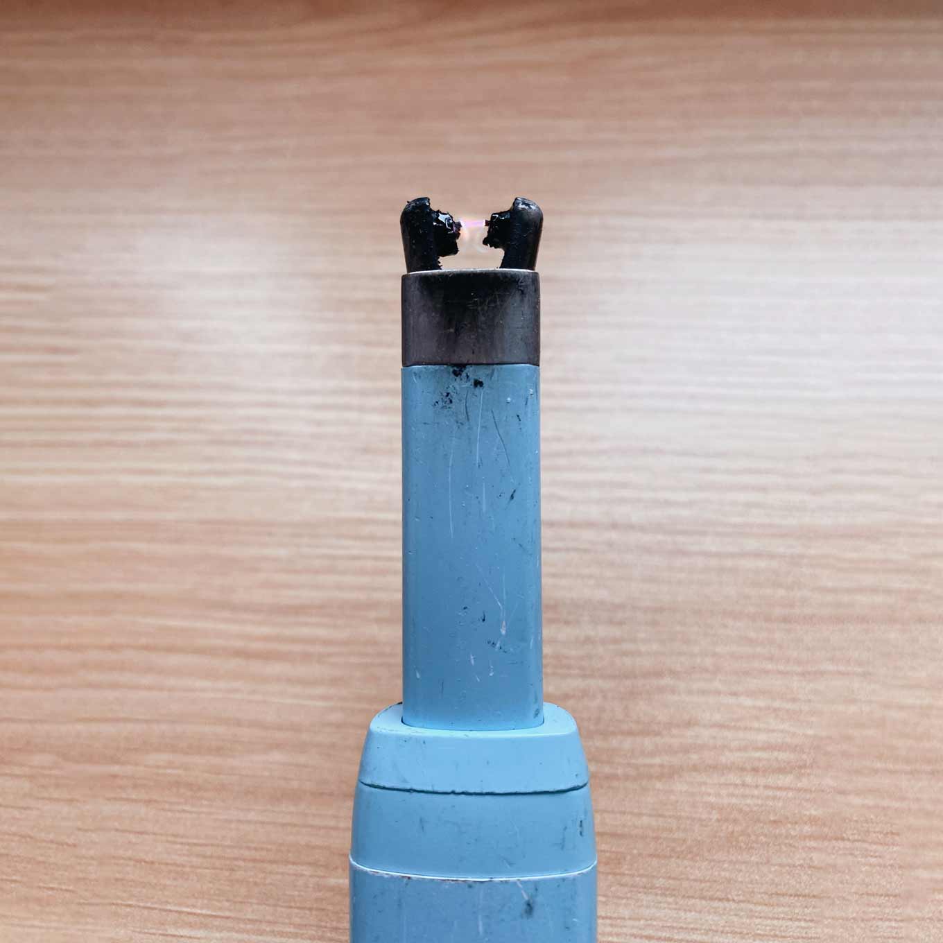 Close-upfoto van elektrische aansteker van The USB Lighter Company, met slijtage, krassen en vuil, maar toch verlichting