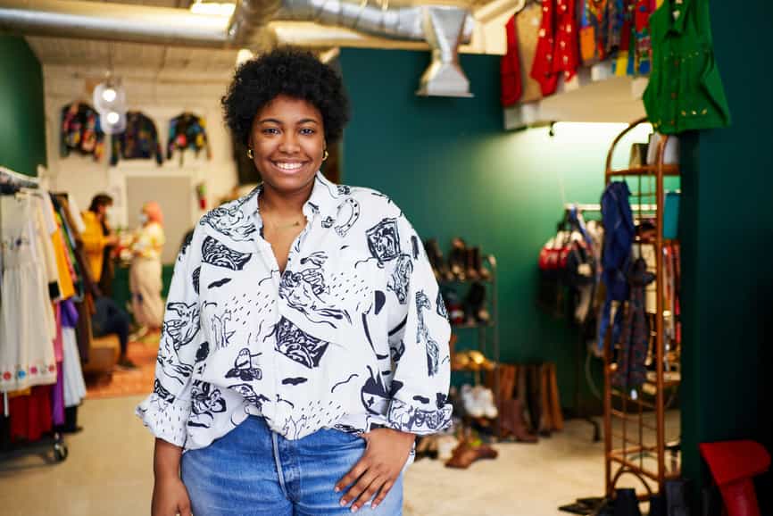 Portret van zelfverzekerde zwarte vrouwelijke winkeleigenaar in haar vintage winkel