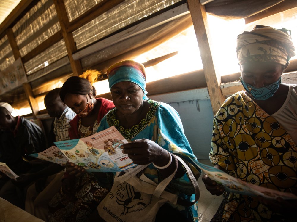 Vrouwen lezen over ebola op een maandelijkse bijeenkomst van overlevenden in Beni, Democratische Republiek Congo. 14 oktober 2021. Overlevendengroepen werken aan het verdrijven van verkeerde informatie over het Ebola-virus, in een poging verdere uitbraken te voorkomen.