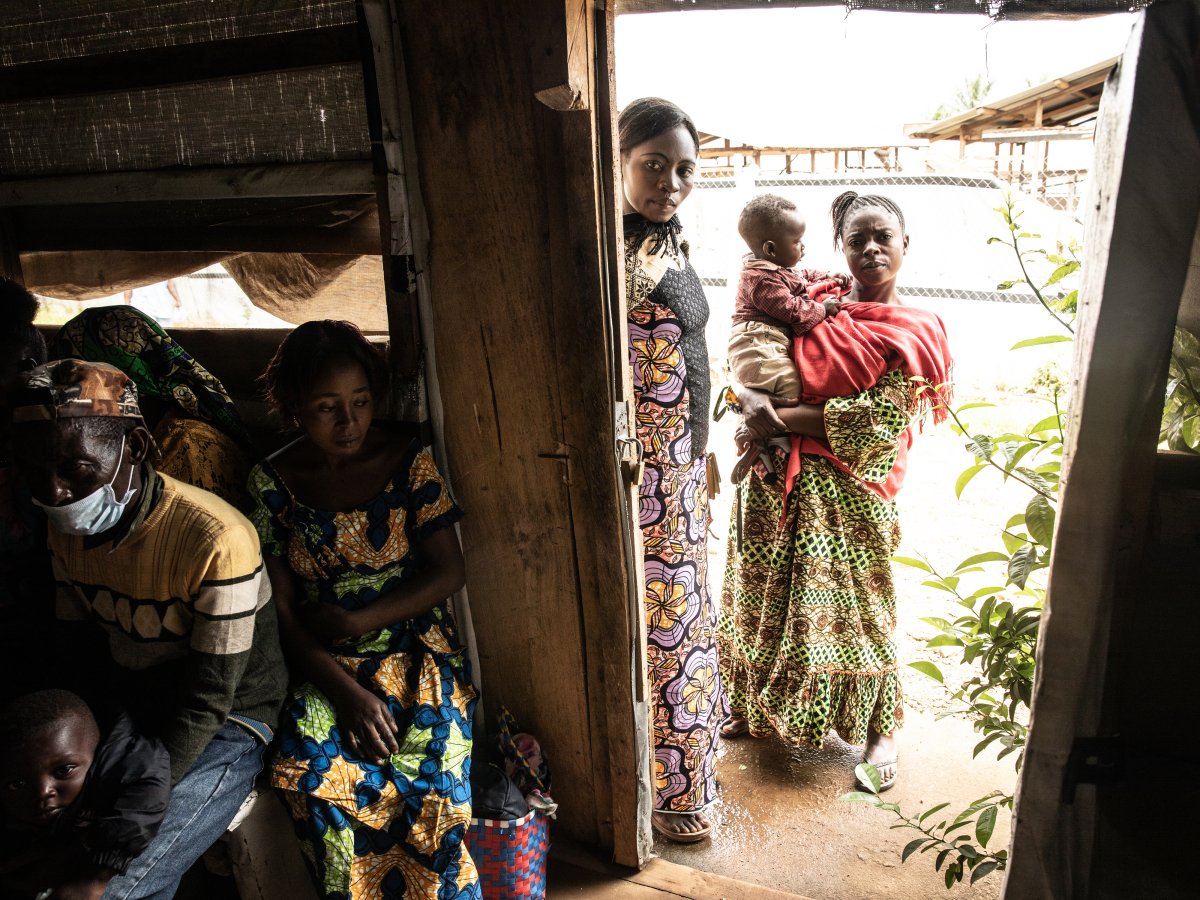 Vrouwen staan in de deuropening van een maandelijkse bijeenkomst van ebola-overlevenden met een jong kind in de stad Beni, Democratische Republiek Congo. 14 oktober 2021. De overlevendengroepen die sinds de laatste grote uitbraak zijn ontstaan, doen outreachwerk in hun gemeenschappen om het bewustzijn te vergroten en verdere uitbraken te voorkomen.