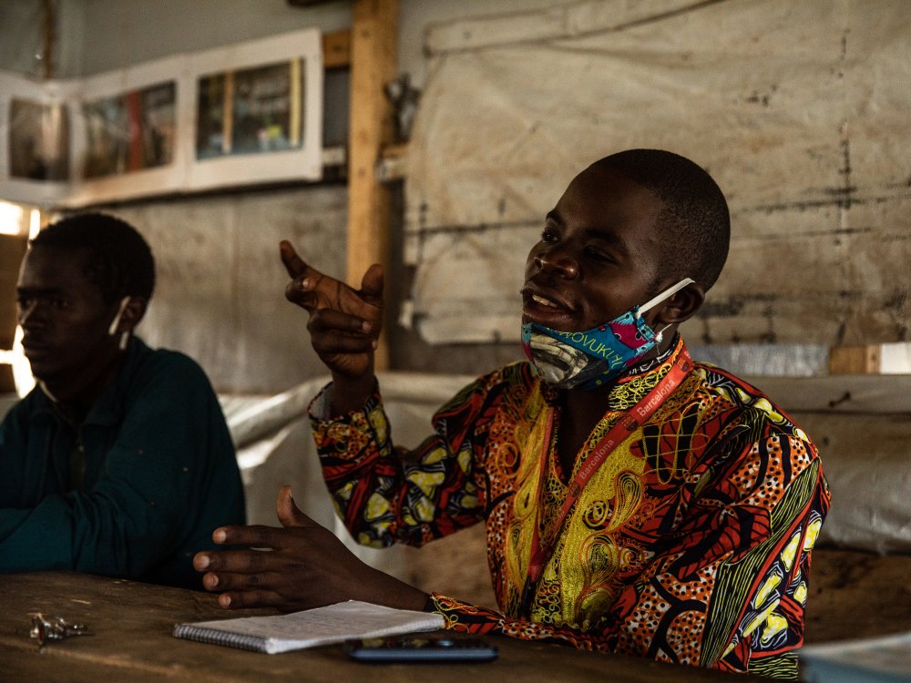 Overlevende Merveille Agasa, 25, zit een maandelijkse bijeenkomst voor van ebola-overlevenden in Beni, Democratische Republiek Congo. 14 oktober 2021. Nadat hij hersteld was van het virus, keerde Agasa terug naar huis en werd hij gemeden door zijn gemeenschap. Hij zei dat zijn familie hem in een garage liet slapen en hem de bijnaam Ebola gaf.