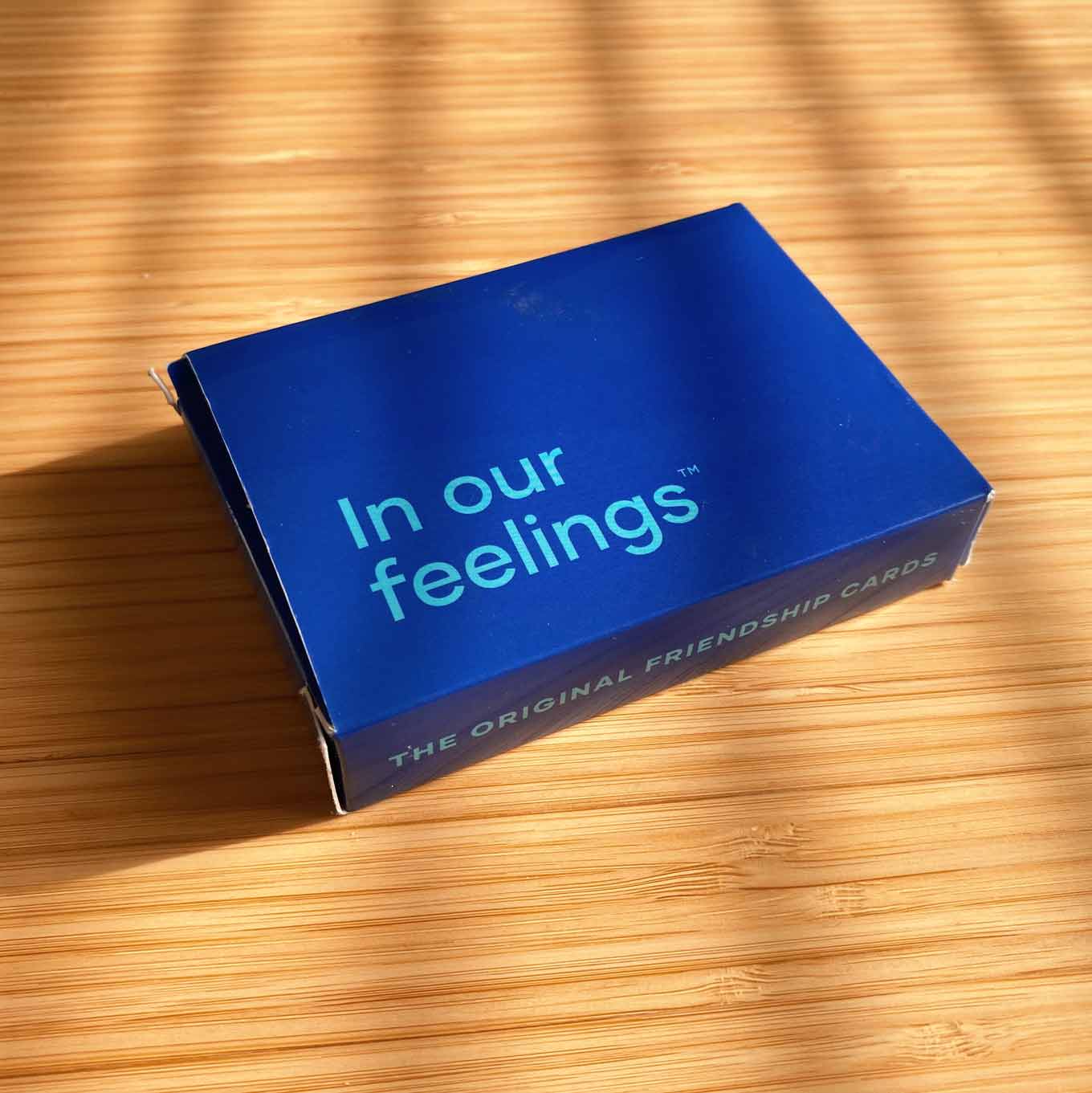 Blauwe doos voor een kaartspel, met de woorden In Ou Feelings: The Original Friendship Cards
