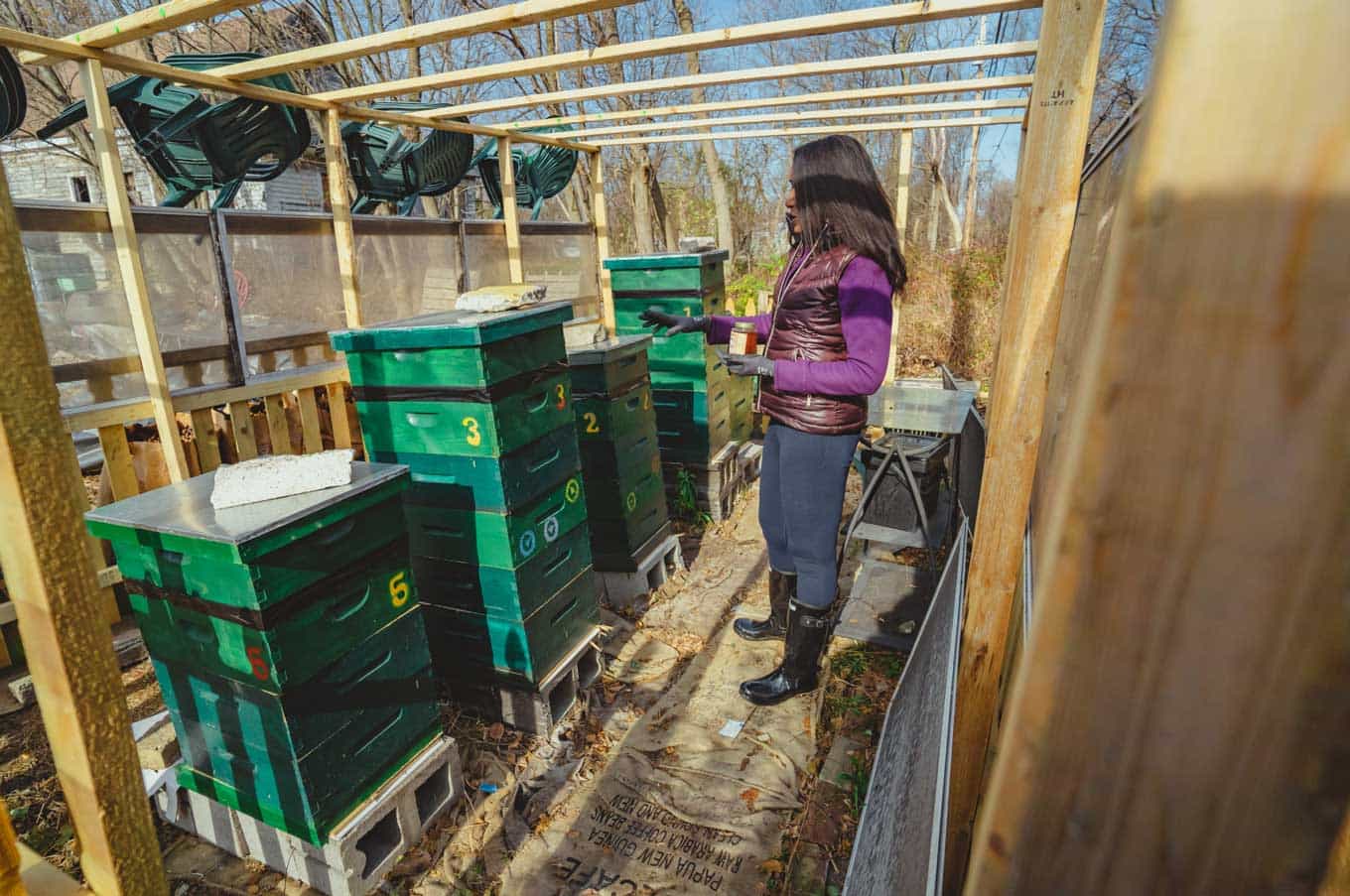 Een warm geklede vrouw legt iets uit op haar boerderij