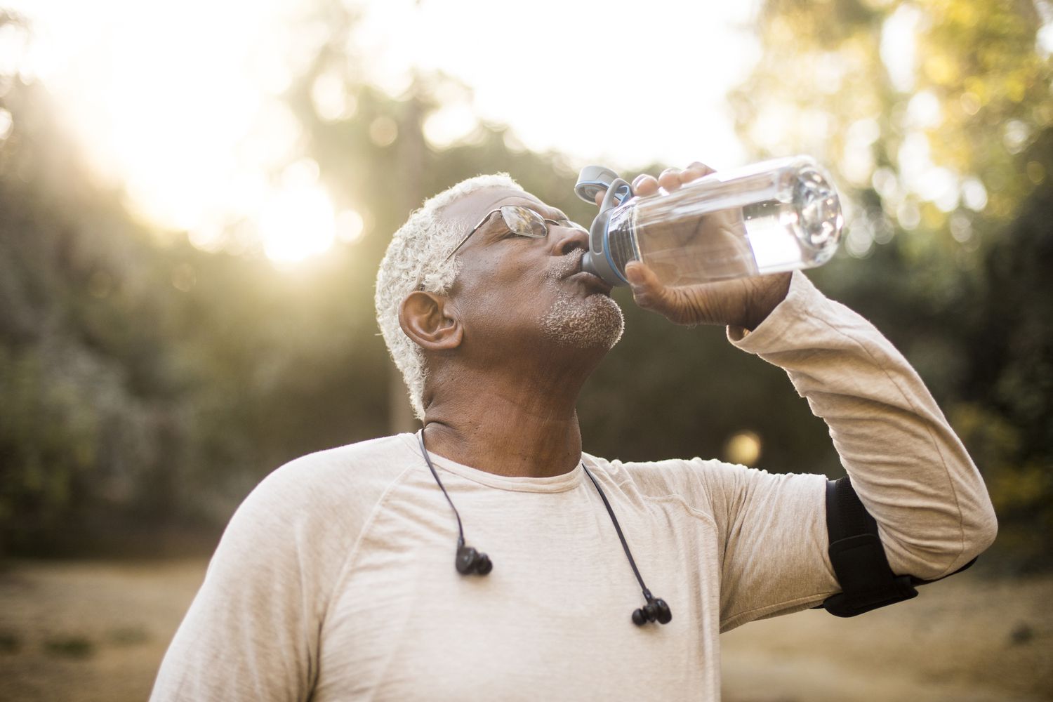 Een oudere Afro-Amerikaanse man die geniet van verfrissend water na een training