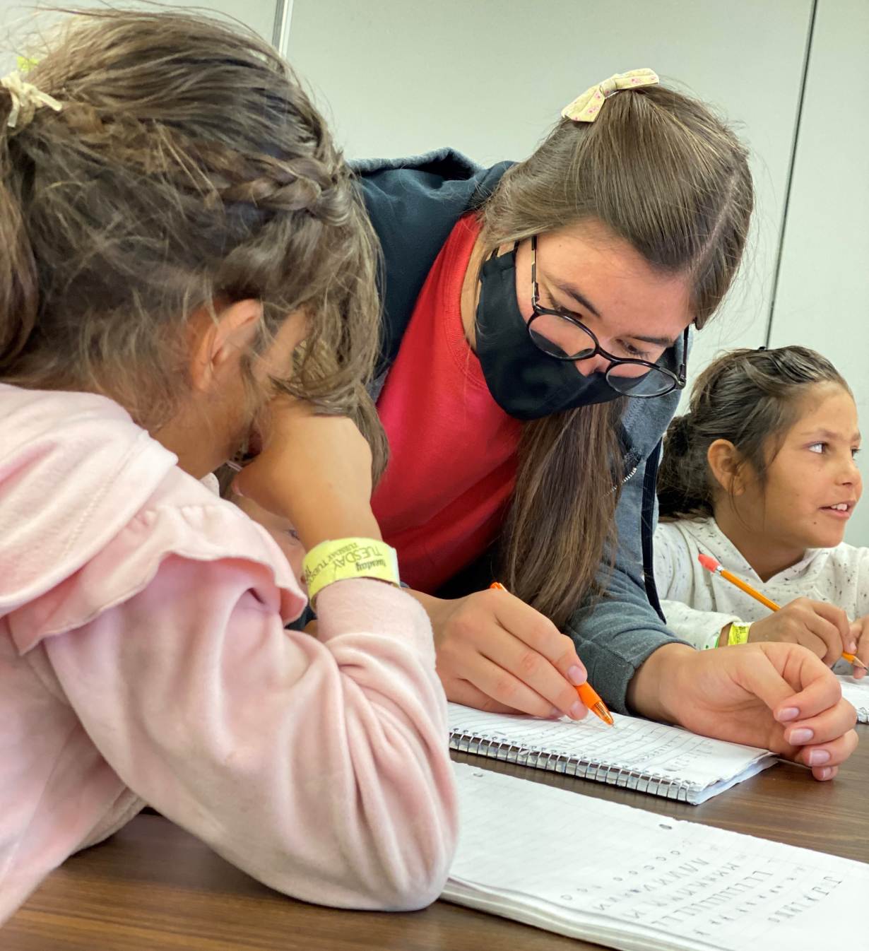 Een leraar die een jonge Afghaanse vluchteling lesgeeft tijdens een Engelse les in een school die in september 2021 door Afghaanse vrouwen is gestart in Fort McCoy, Wisconsin.