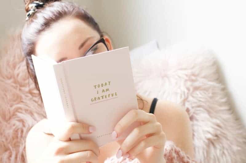 meisje dat dankbaarheidsdagboek leest