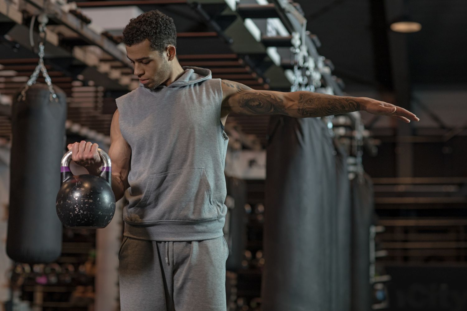 Jonge knappe gemengde race Boxer Fighter traint hard met een kettlebell in Gym
