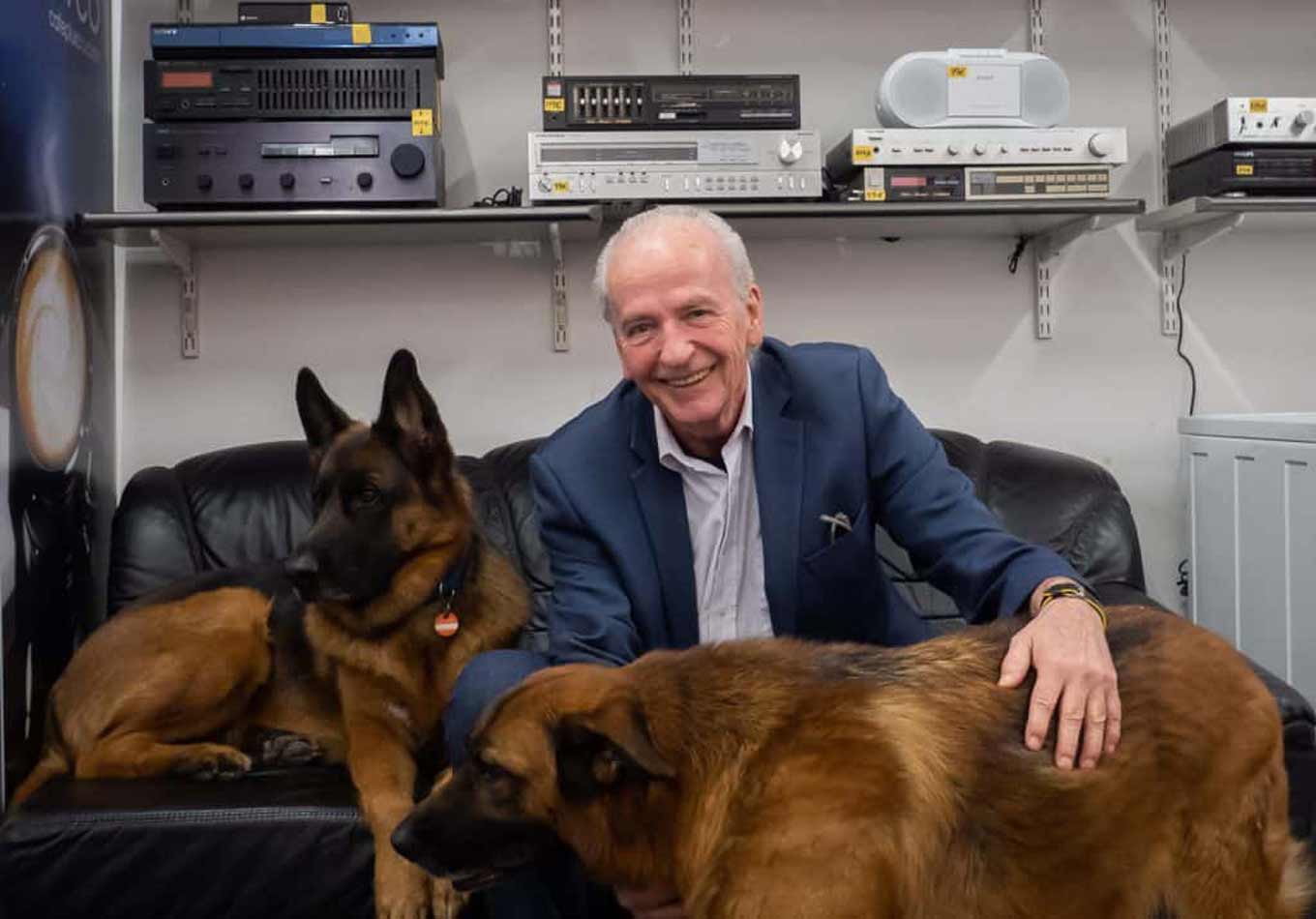 Sepp Eisenriegler poseert glimlachend voor de camera met zijn twee honden