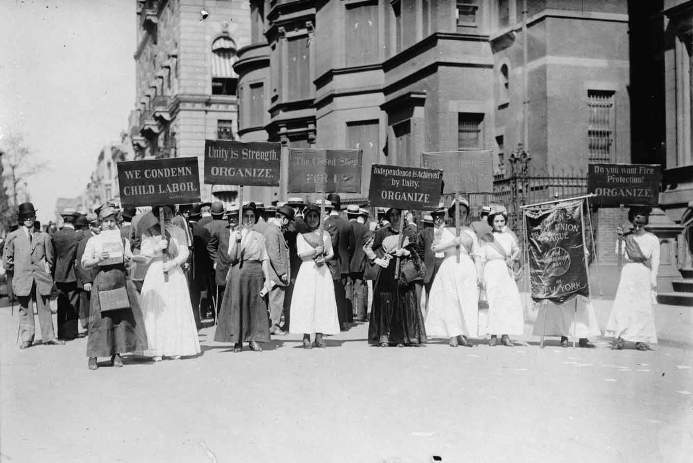 Historische foto van vrouwen die demonstreerden tegen kinderarbeid in New York City in de vroege jaren 1900 - met borden die dingen zeggen als "Wij veroordelen kinderarbeid" en"Eenheid is Kracht - Organiseren"