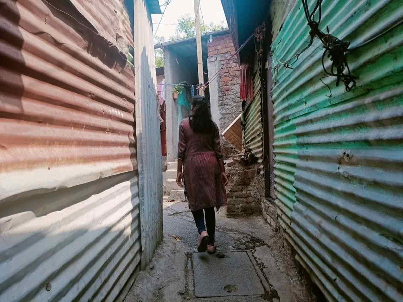 Priyanka loopt tussen twee huizen in haar buurt