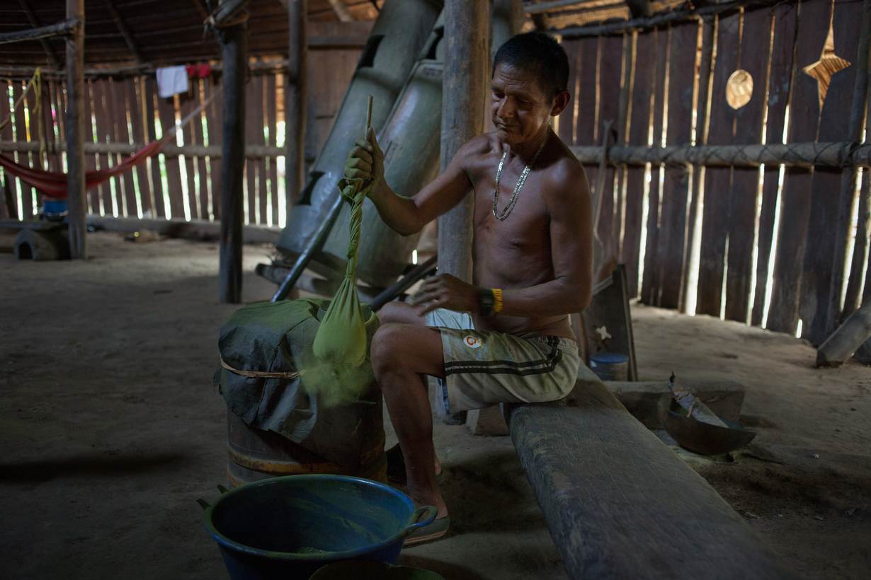 Een inheemse man bereidt poedervormige cocabladeren die worden gebruikt in het eeuwenoude mambe-ritueel, Puerto Libre-riviergemeenschap, provincie Amazonas, Miriti- Parana, Colombia
