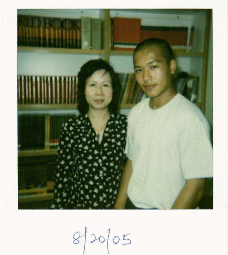 Een polaroid van Jason Wang en zijn moeder voor boekenkasten, gedateerd 20-8-05