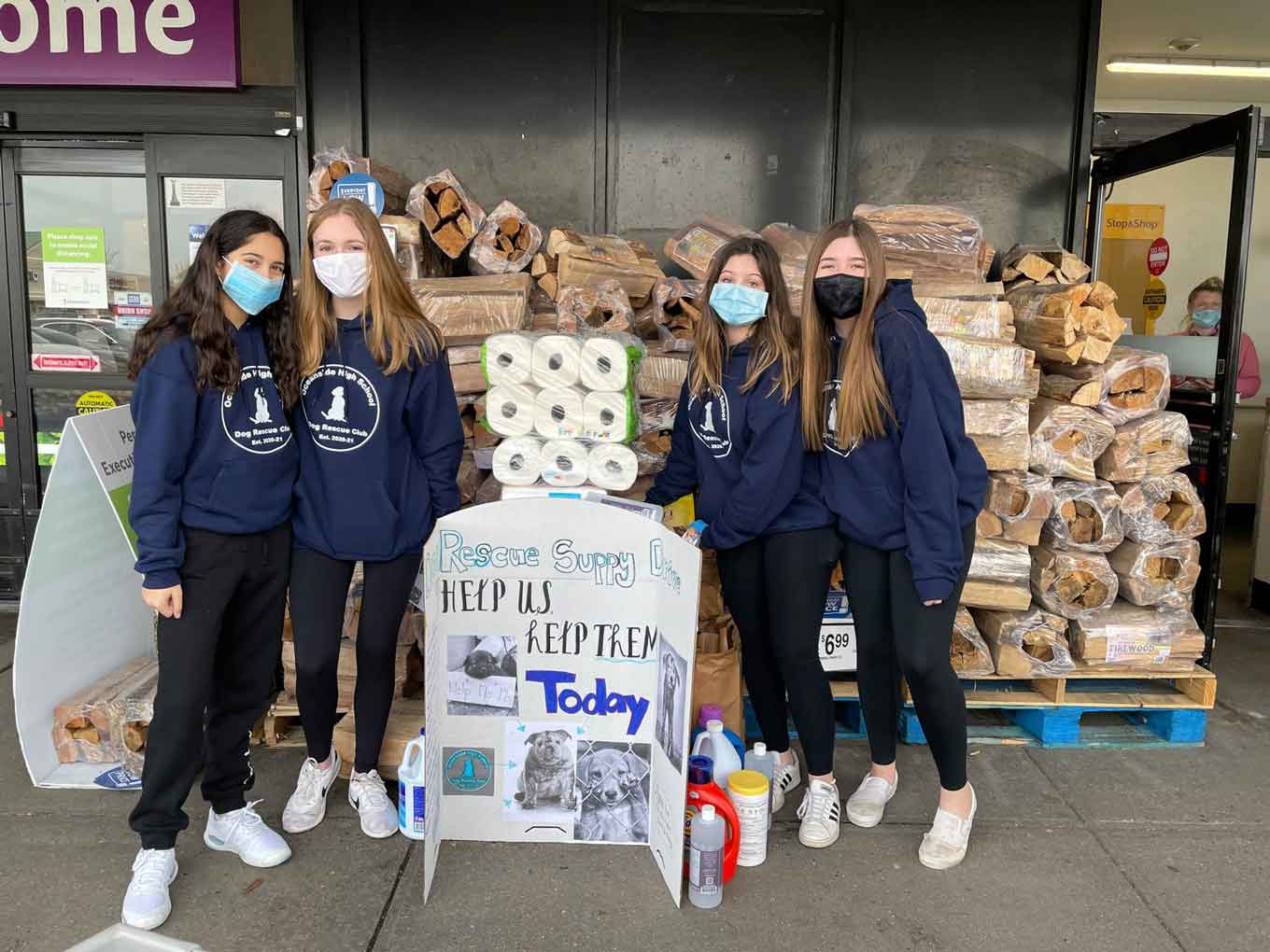 Vier tienermeisjes buiten een supermarkt, geld inzamelen voor hondenadoptie