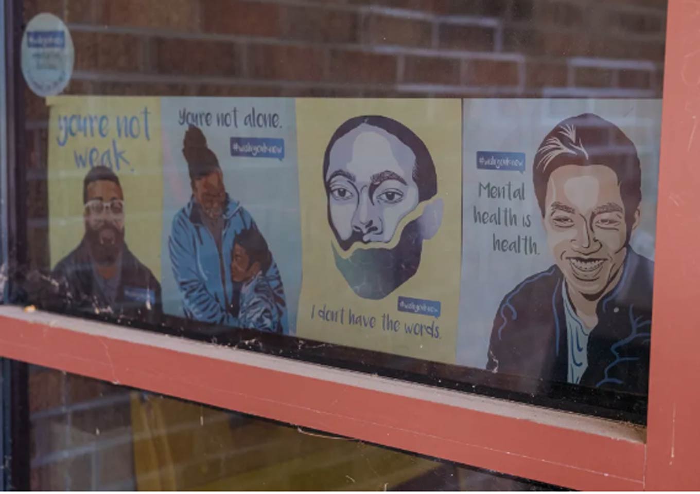 Een raam met posters met positieve geestelijke gezondheidsboodschappen