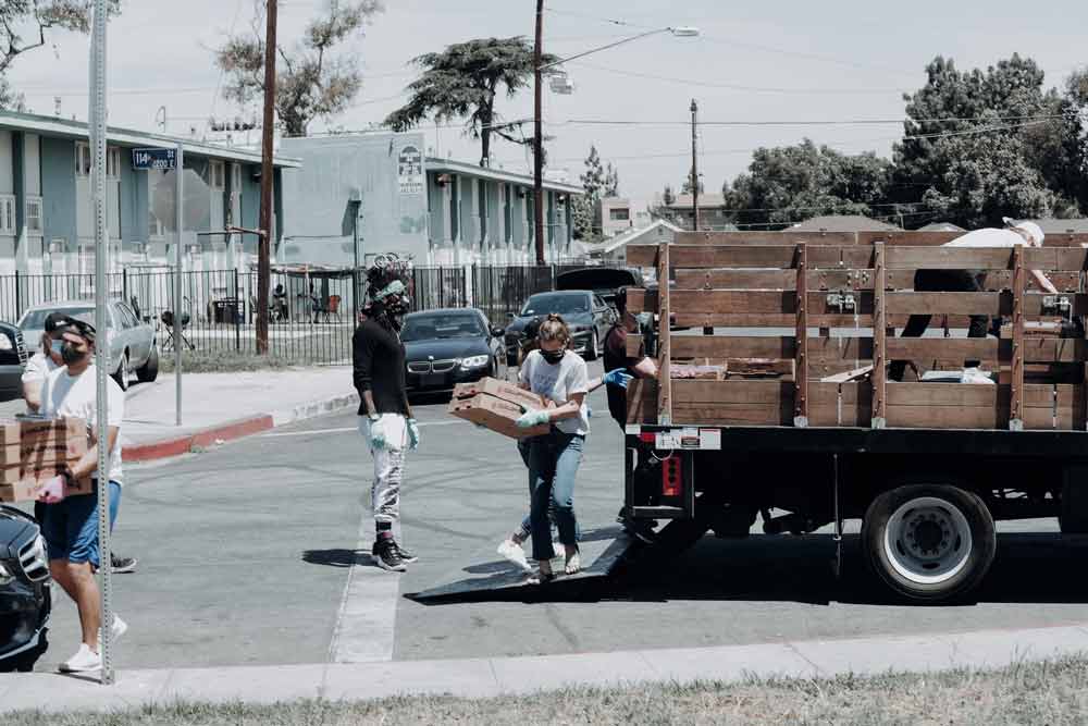 Een groep vrijwilligers die wederzijdse hulpgoederen vanuit een vrachtwagen vervoert