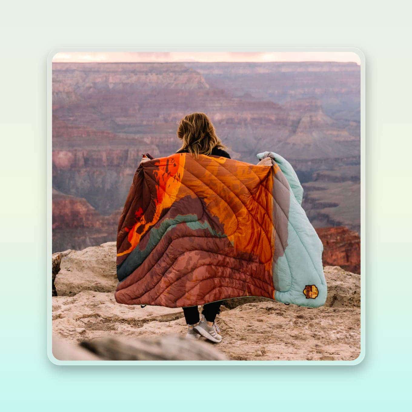 Een vrouw houdt een pufferdeken vast bij de Grand Canyon