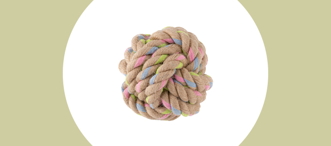 Een bal gemaakt van dikke strengen bruin touw met blauwe, roze en groene kleuren erin geweven.