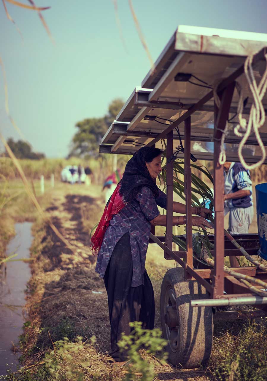 Een Indiase vrouw werkt aan een set zonnepanelen gemonteerd op een mobiele trailer