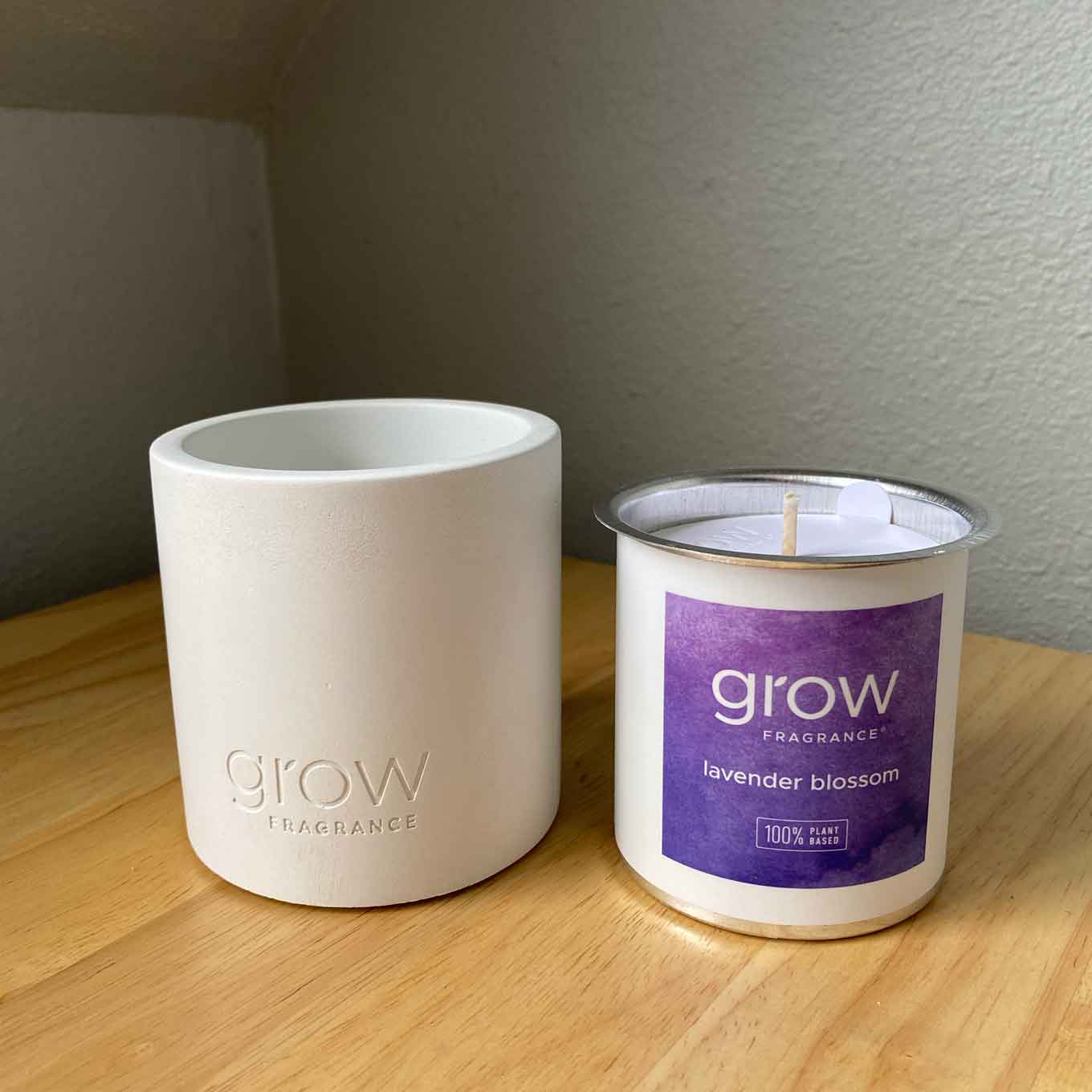 Een wit betonnen vat, een aluminium kaarsinzet van Grow Fragrances, met een label waarop lavendel blossume staat
