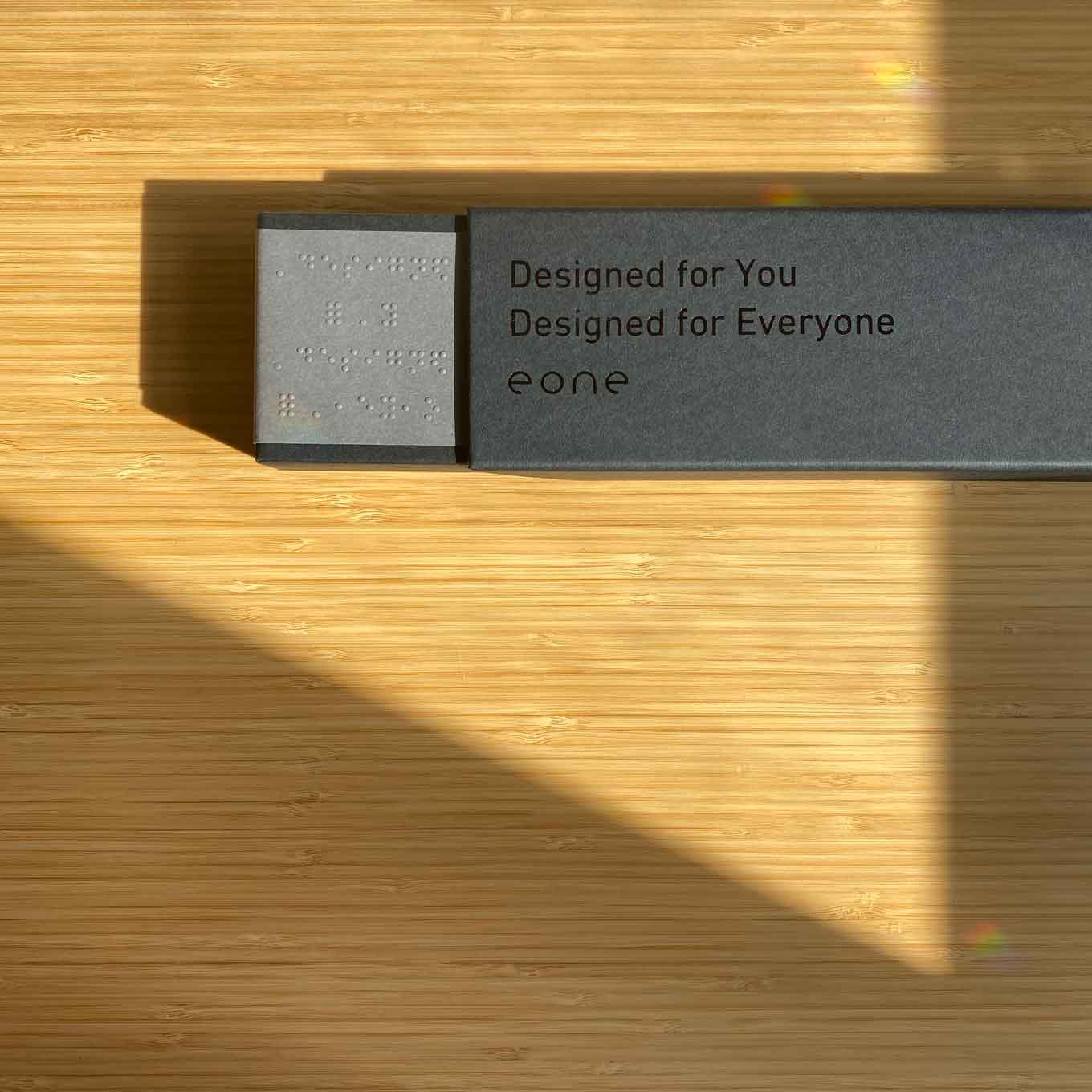 Verpakking die zegt "Ontworpen voor u. Ontworpen voor iedereen. Eone" in braille