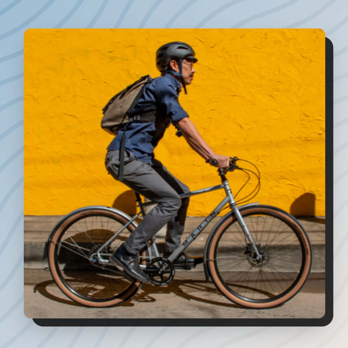 Persoon die voor een gele muur fietst