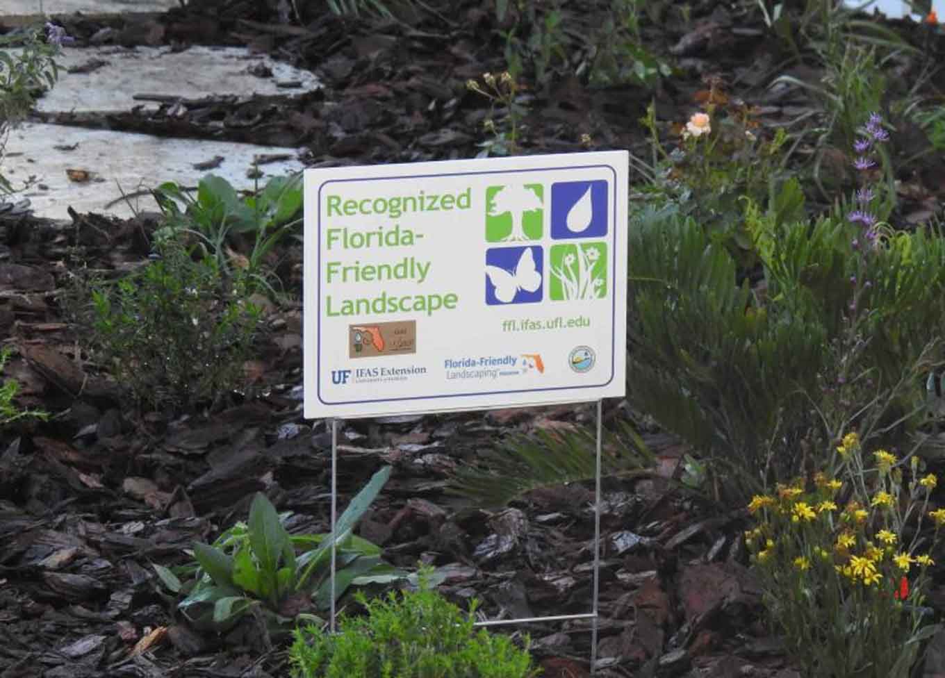 Een bord in het midden van een landschap dat zegt "Erkend Florida-vriendelijk landschap"
