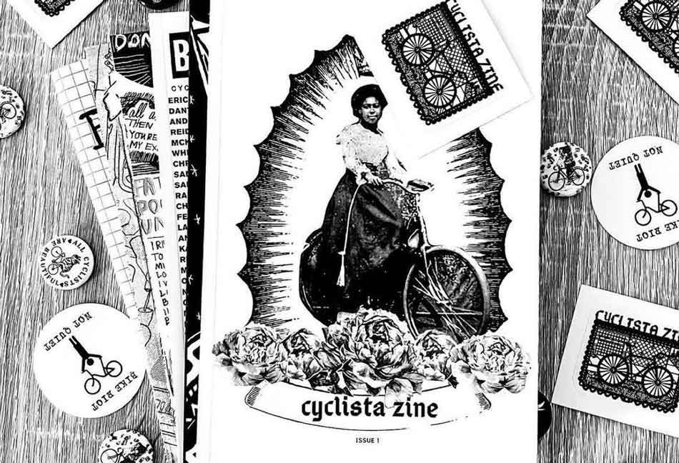 Een exemplaar van Cyclista Zine ligt op een tafel omringd door knopen en stickers.