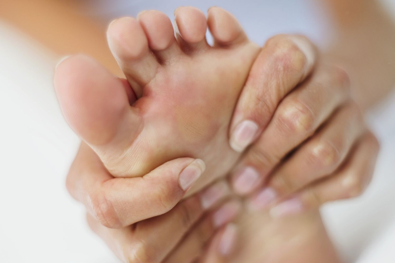 vrouwenhanden die voet masseren