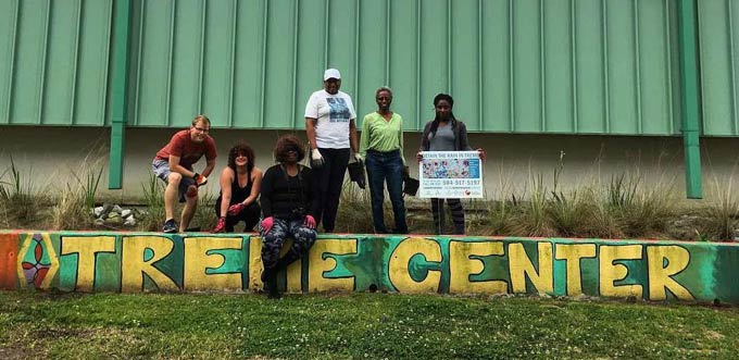 Een groep Vrijwilligers van Water Wise poseert in het Treme Center, een plantenbak die is ontworpen om regenwater op te vangen in New Orleans