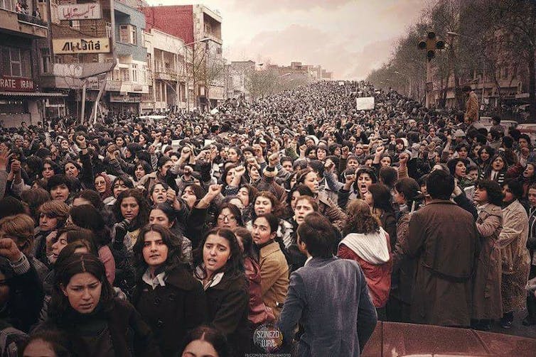 Een grote groep vrouwen marcheert door een straat.