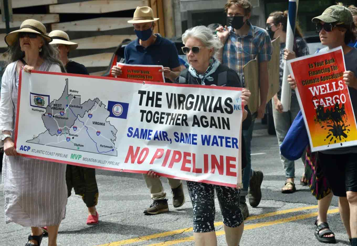 Een groep die protesteert terwijl twee van hen samen een bord vasthouden