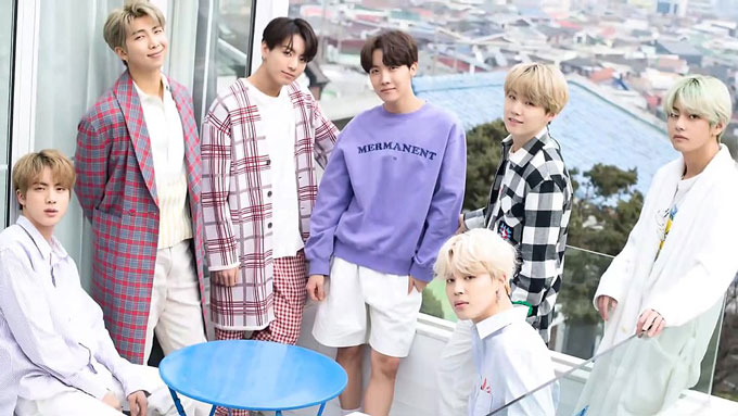 7 leden van BTS, poseren en kijken naar de camera