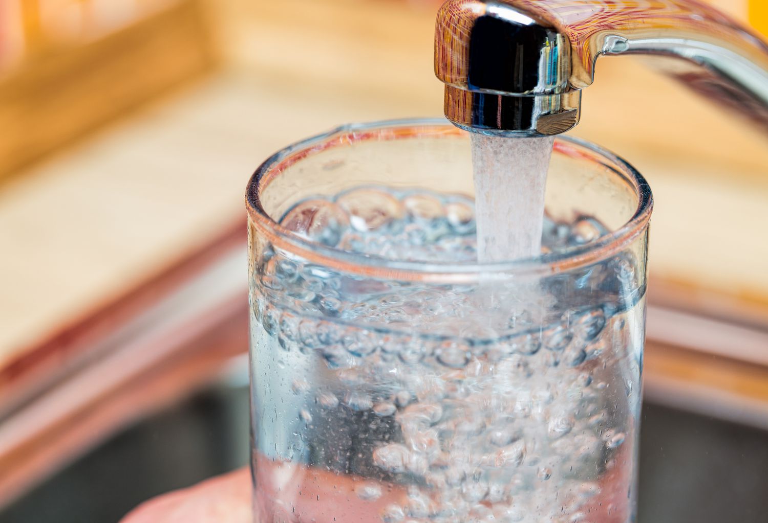Een glas vullen met drinkwater uit keukenkraan