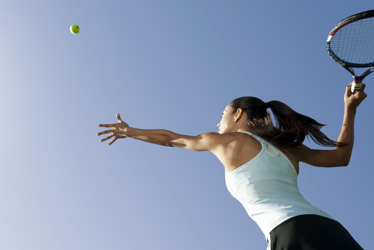 Vrouwelijke tennisser die bal serveert, lage hoekweergave