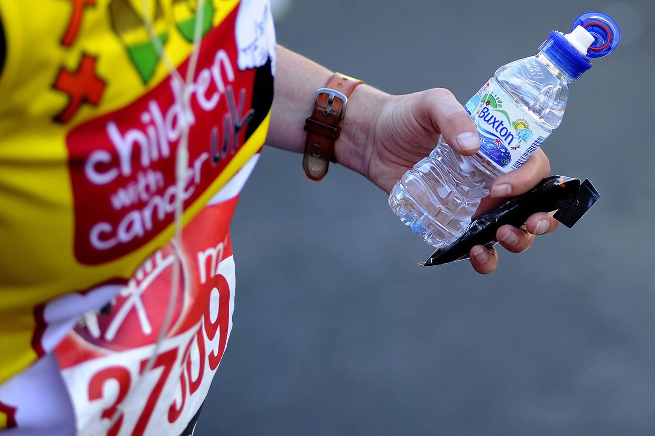 Een hardloper houdt een energiereep en een fles water vast tijdens de Virgin Money London Marathon op 13 april 2014 in Londen, Engeland.