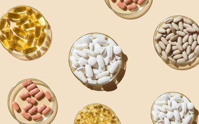 Verschillende pillen en capsules, vitamines en voedingssupplementen in petrischalen op een beige achtergrond