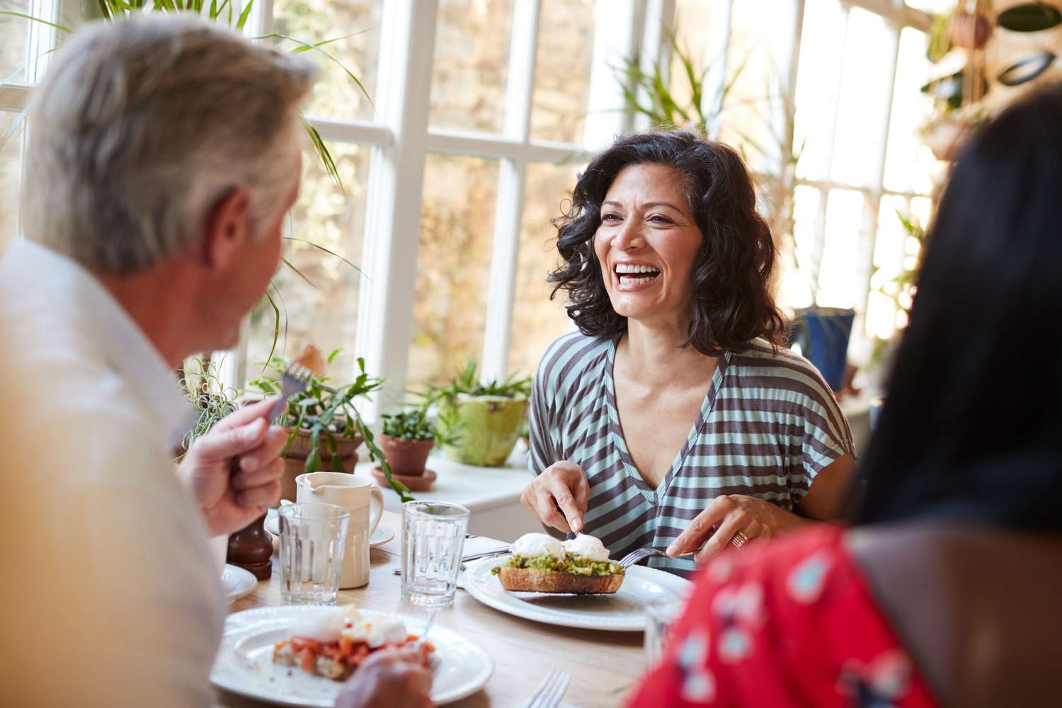 Vrouw die lacht met een mannelijke vriend tijdens het eten in een café