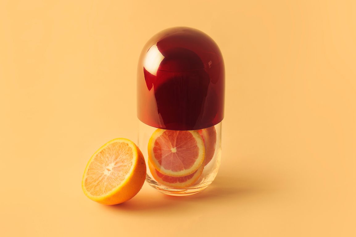 Sinaasappels in heldere capsule om vitamine C-supplementen te vertegenwoordigen