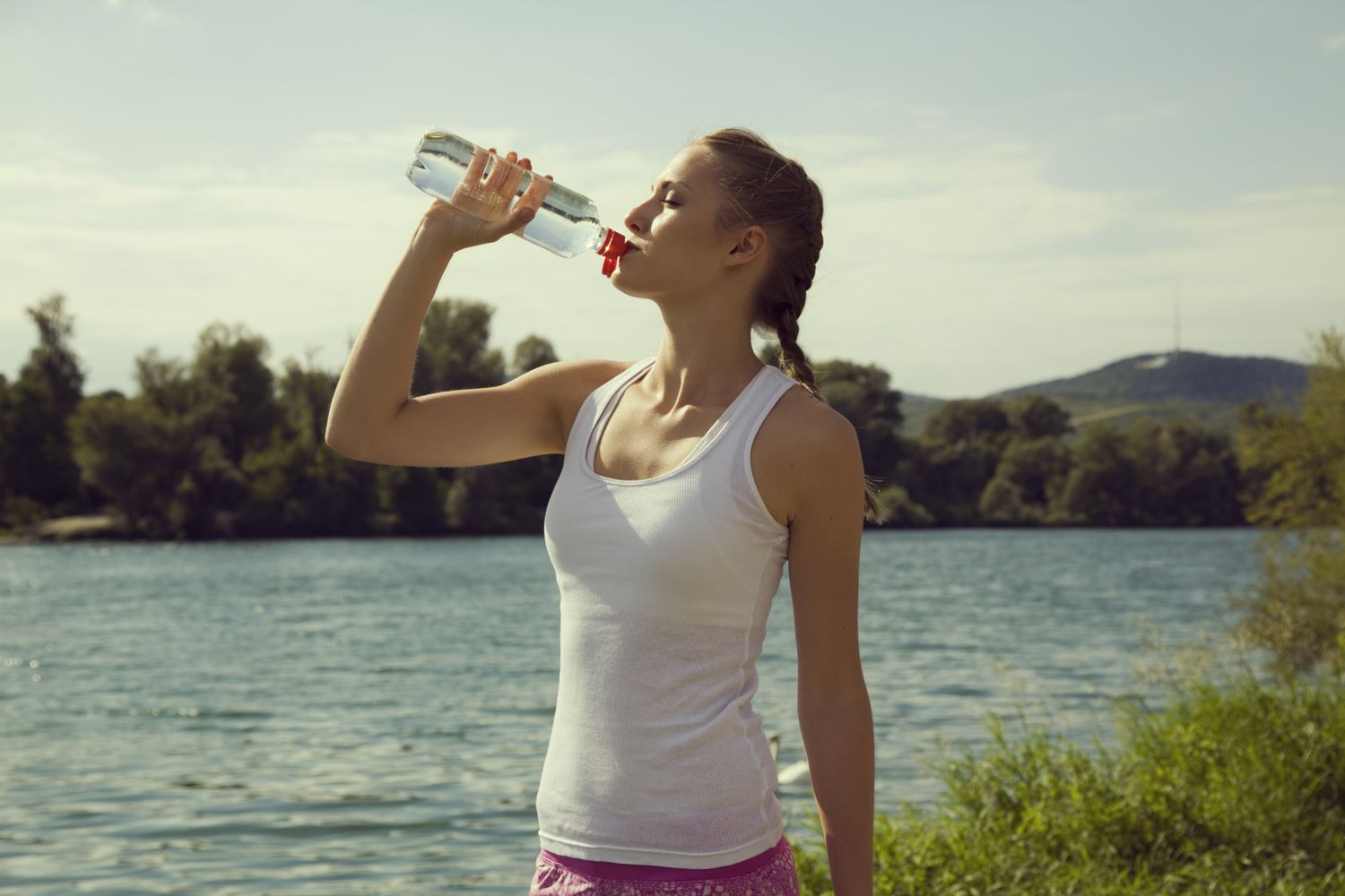 Vrouw die water uit waterfles drinkt