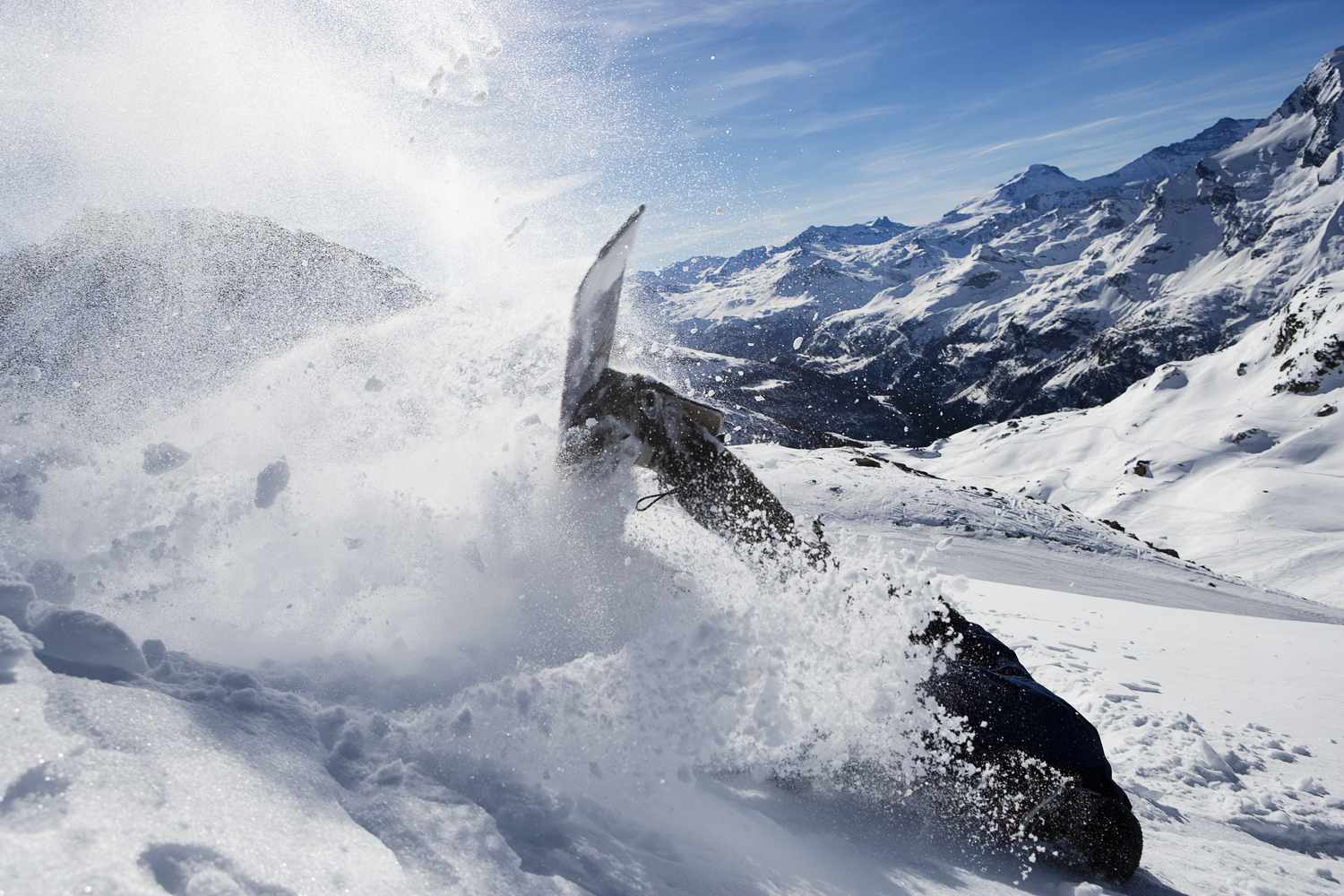 Mannelijke snowboarder die omvalt op berg
