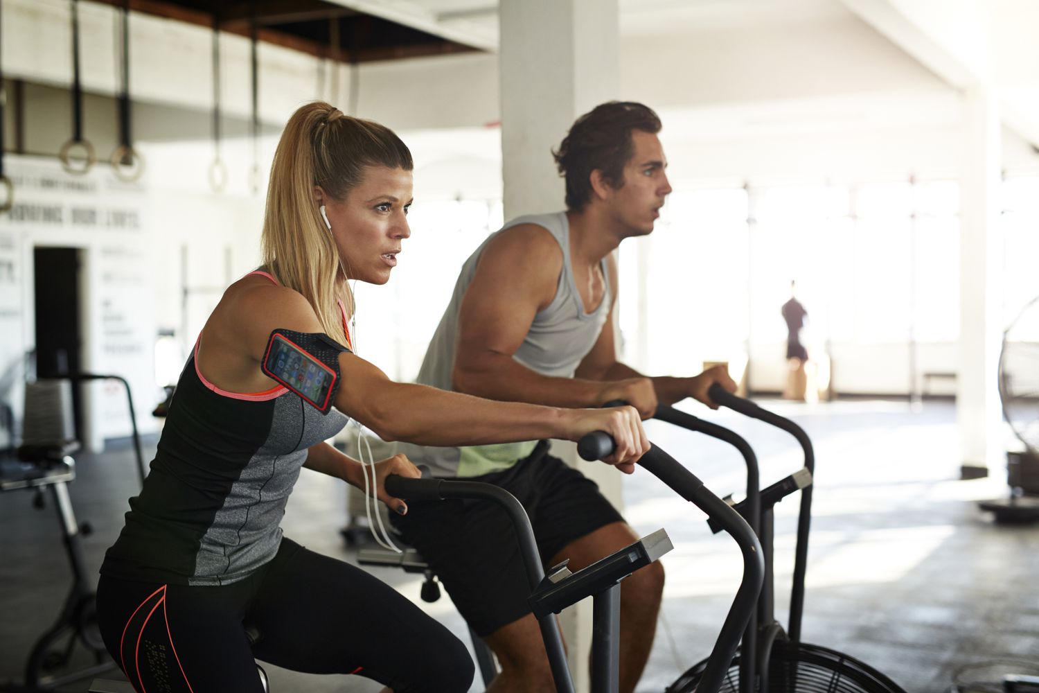 Vrouw &man trainen op crosscycle in de sportschool