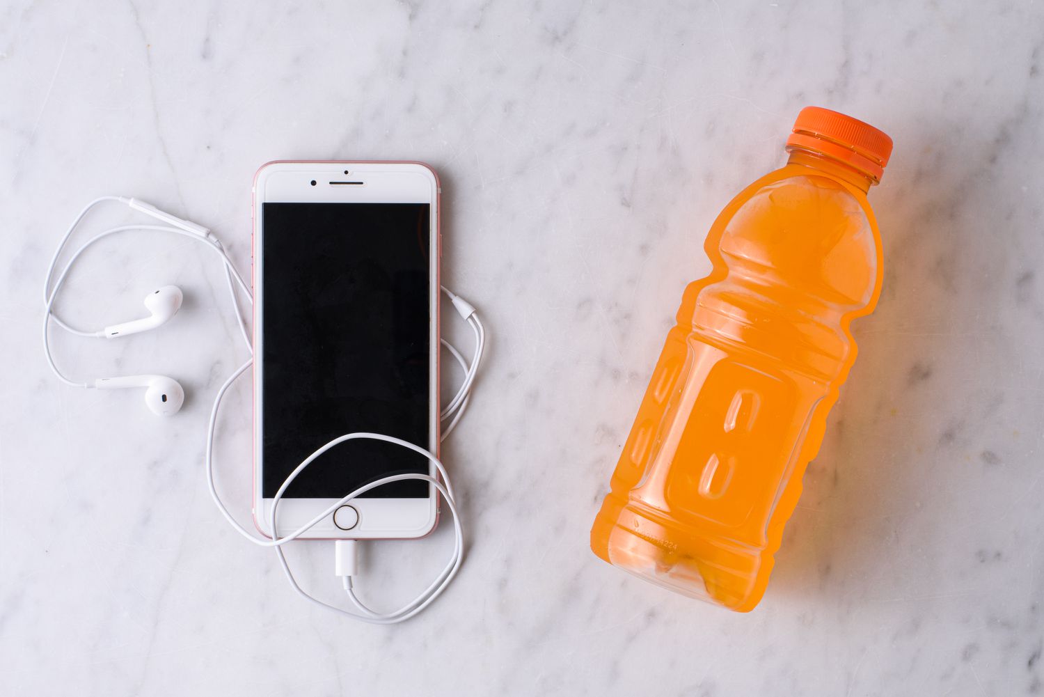 sportdrankfles met iPhone en hoofdtelefoon voor lichaamsbeweging